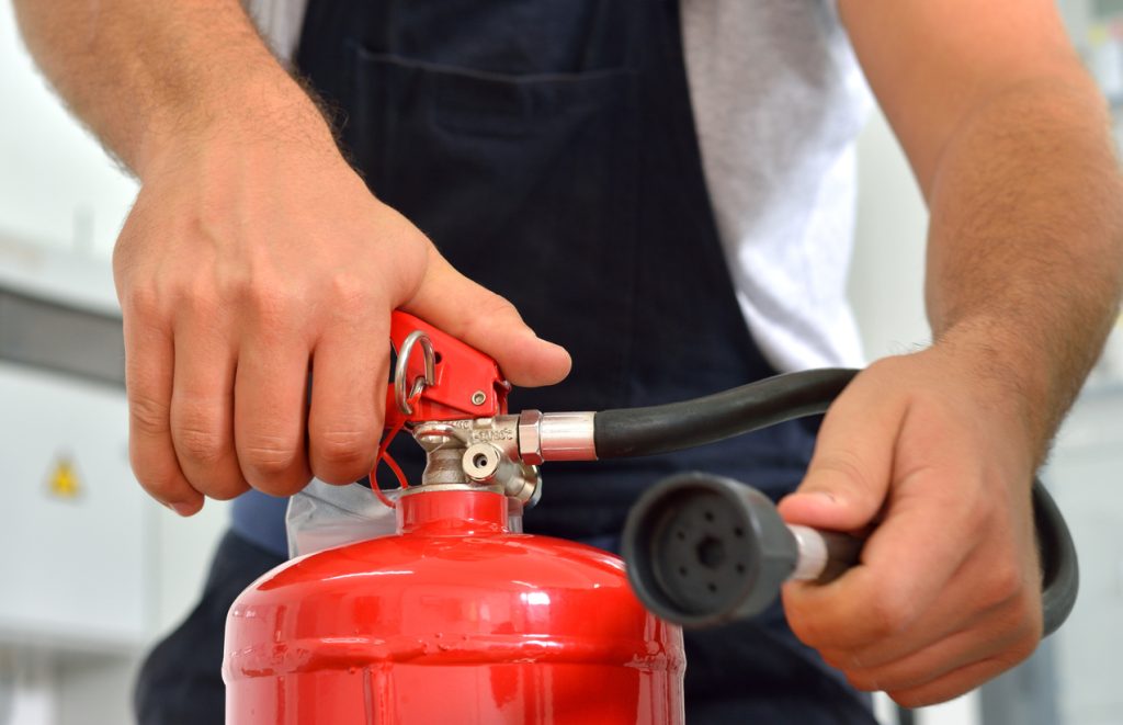 Worker demonstrates the use of fire extinguishers.